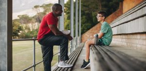 Sports coach talking to his student anxiety in athletes.